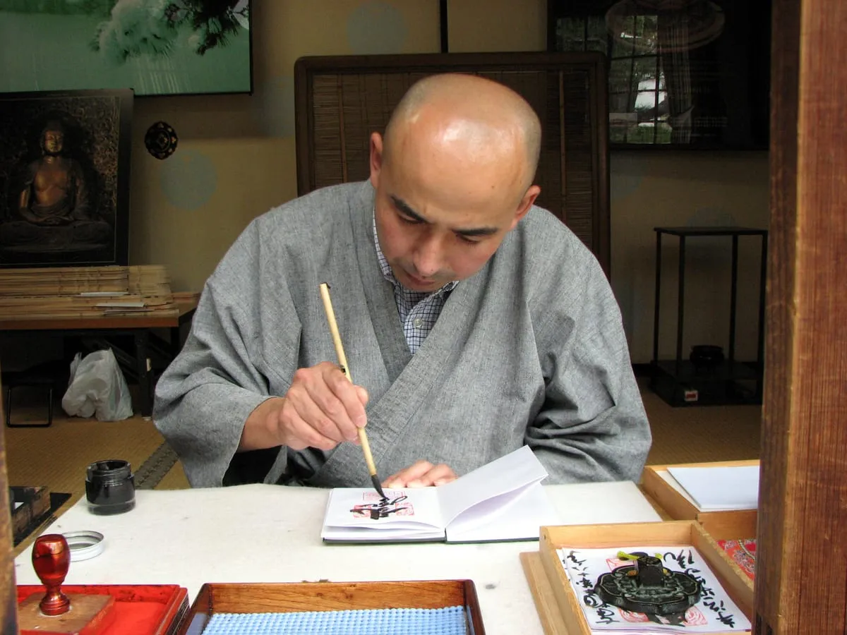 A calligrapher writing in a goshuin book at Byodo-in temple