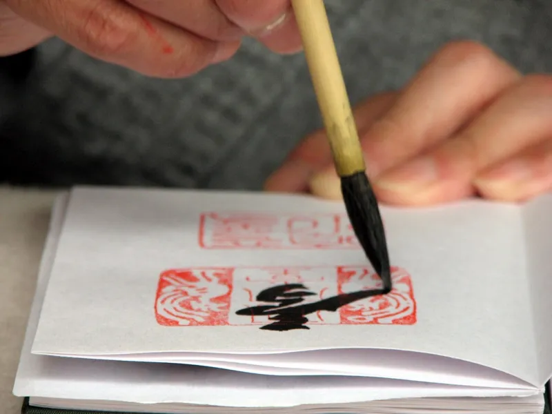 平等院で御朱印を書く僧侶。一筆一筆に集中する様子が伝わる