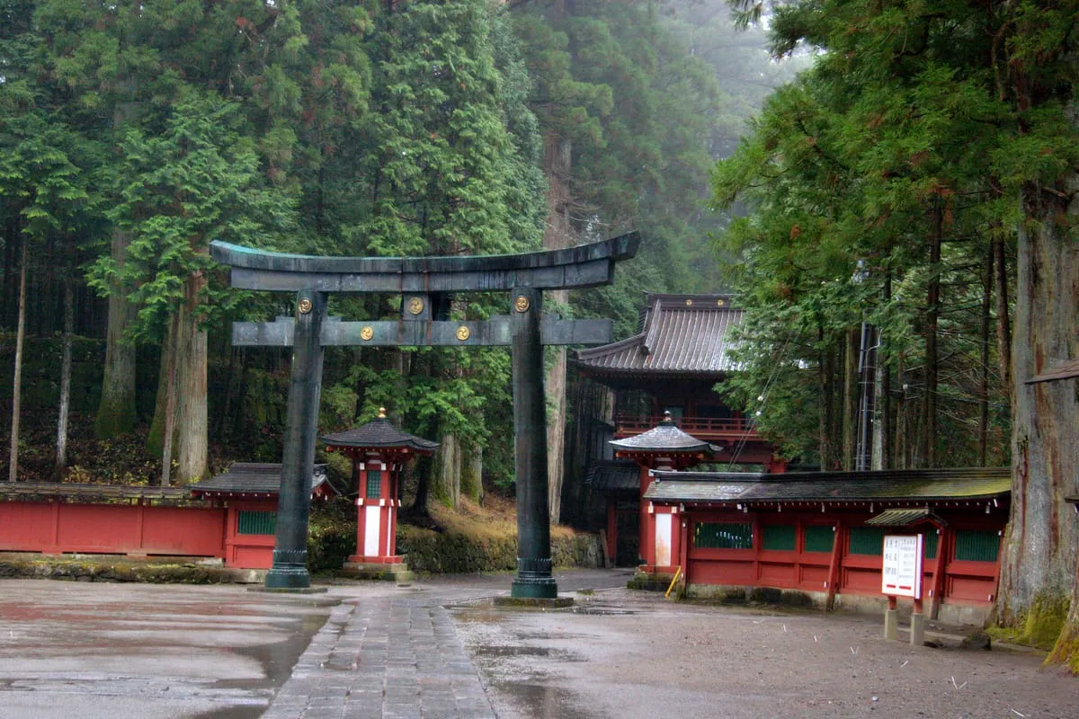 Bronze torii gate at Futarasan Shrine in Nikko, in the rain